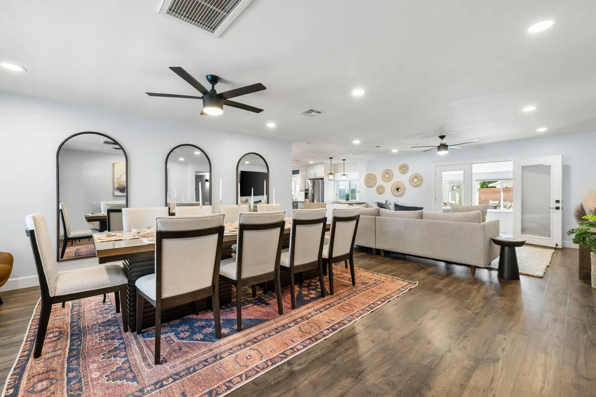 A welcoming dining area with a large table, mirrors, a comfortable sofa, and decorative wall plates. The setup is perfect for family dinners, celebrations, and group gatherings, reinforcing the communal dining experience adjacent to the kitchen.